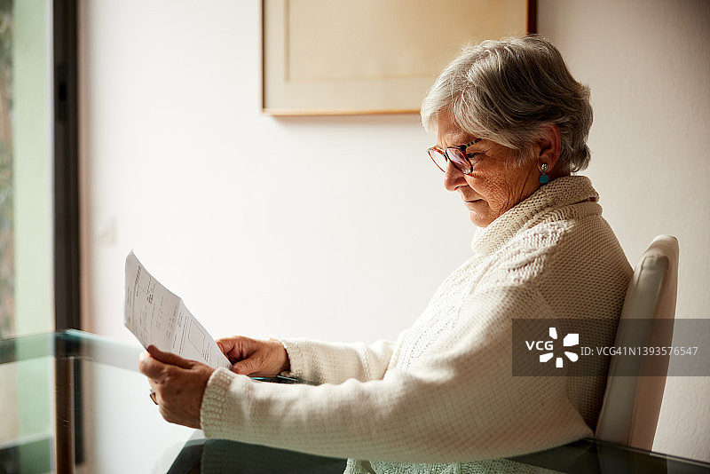 在家中阅读信件的年长女性图片素材
