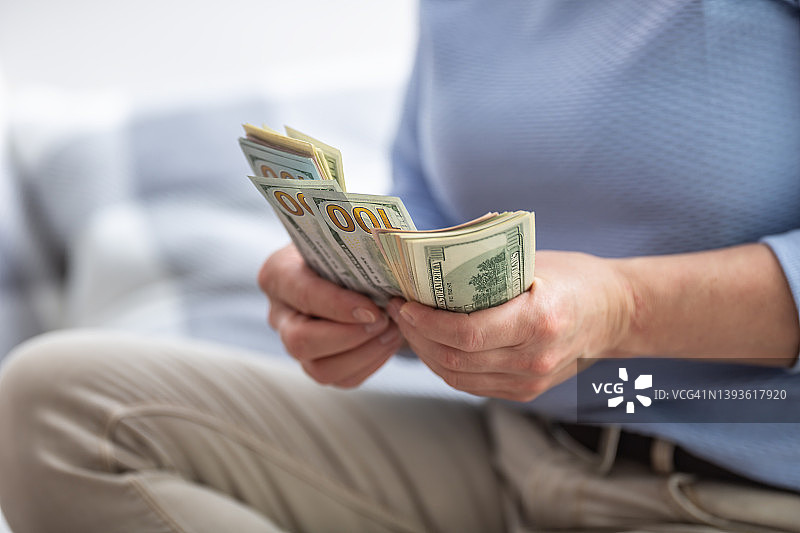 女人手中拿着崭新的美元钞票图片素材