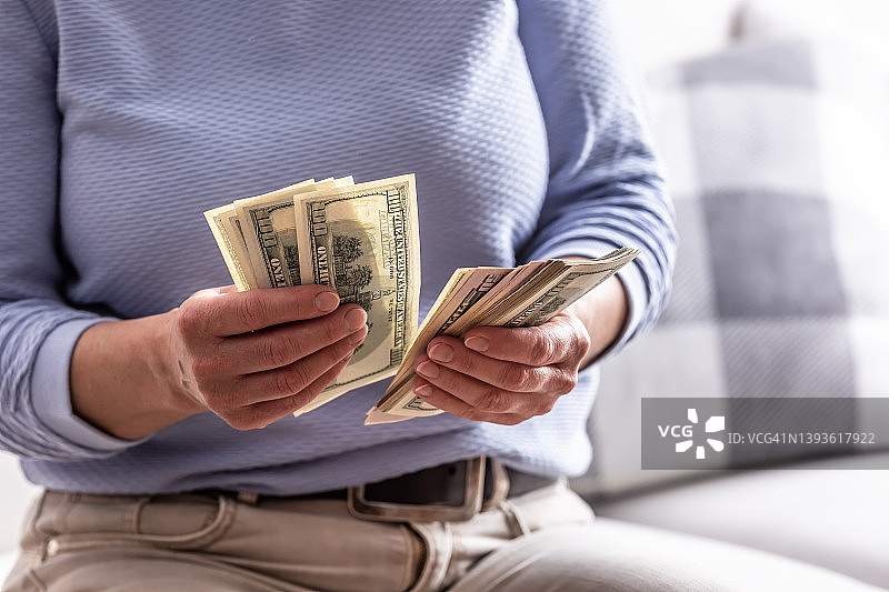女人手中拿着崭新的美元钞票图片素材