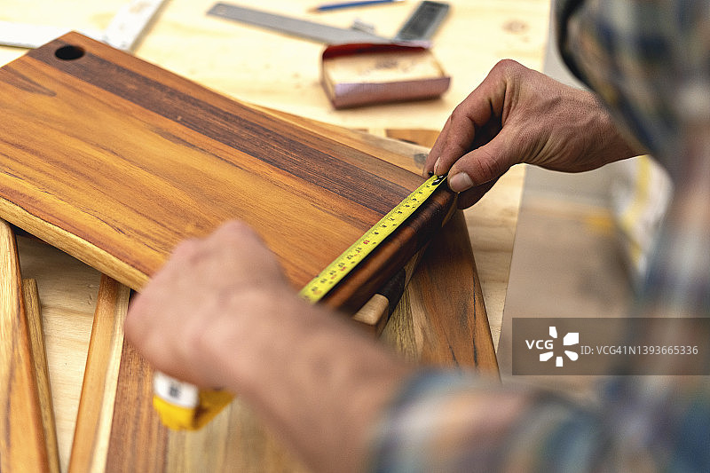 木匠在工作场所用米尺测量木板图片素材