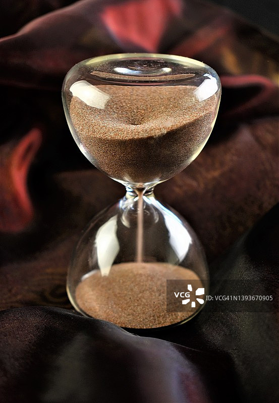 棕色丝绸上的沙漏图片素材