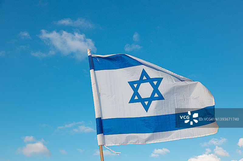 以色列国旗在蓝天下飘扬图片素材
