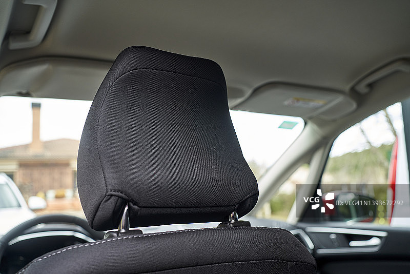 车内驾驶座头枕景观，背景为带烟囱的砖房图片素材