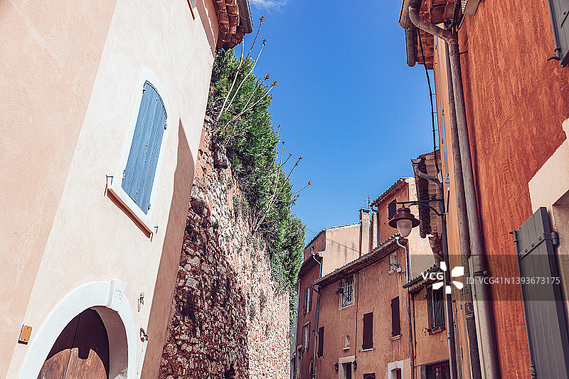 中世纪小巷：陶土色墙壁与蓝色天空图片素材
