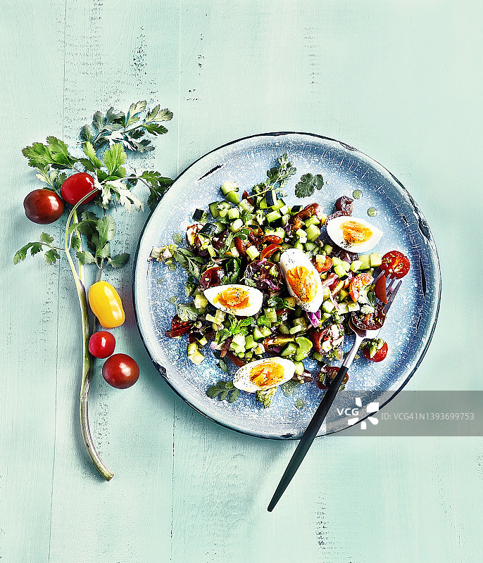 绿松石背景上的鲜沙拉和煮鸡蛋拼盘图片素材
