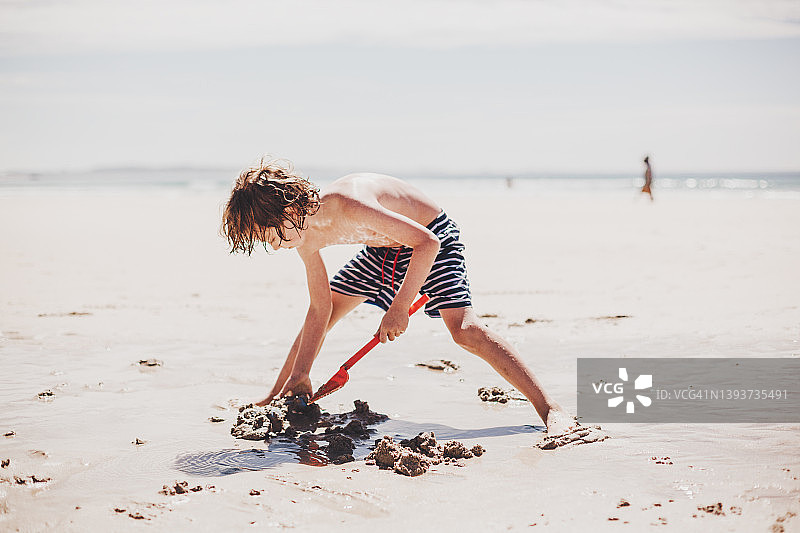 夏季假期在空旷海滩上玩耍的男孩图片素材