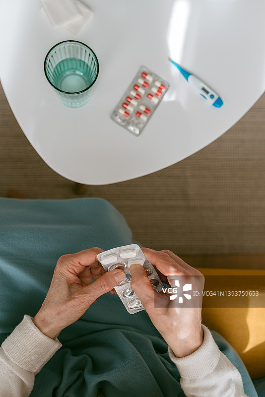 从泡罩包装中取药的女性俯视图图片素材