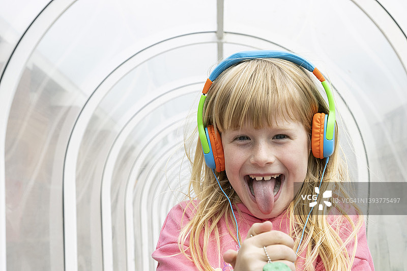 隧道里戴着耳机微笑的小女孩（6-7岁）图片素材