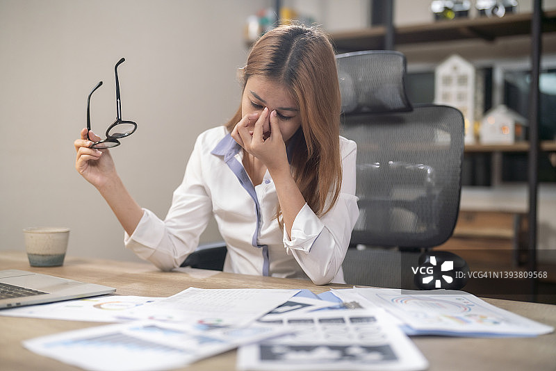疲惫的女商人摘下眼镜，厌倦了电脑工作图片素材