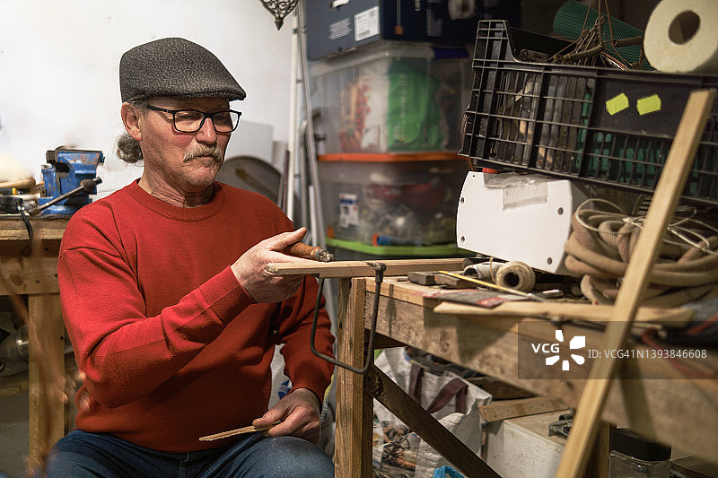 退休男人在工作室用弓锯木工，木工概念图片素材