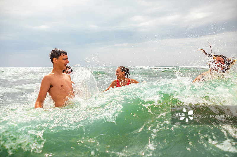 在暑假期间在海中玩耍的快乐年轻朋友图片素材