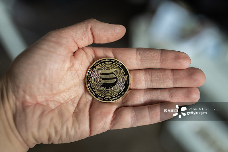 手持Solana SOL加密货币实体硬币图片素材