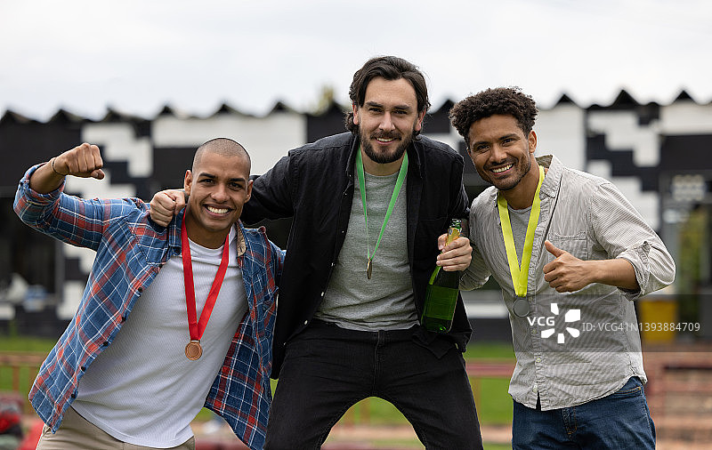 一群快乐的男人在比赛后于领奖台上庆祝图片素材