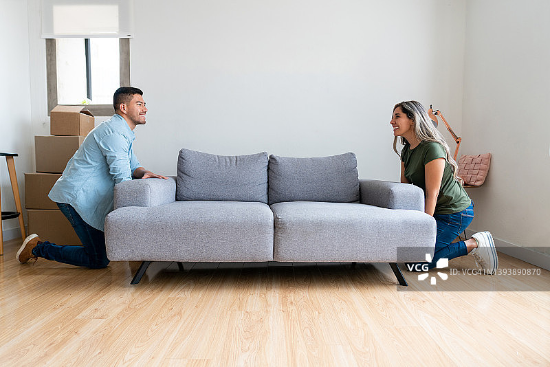 情侣搬家，在客厅里放置沙发图片素材