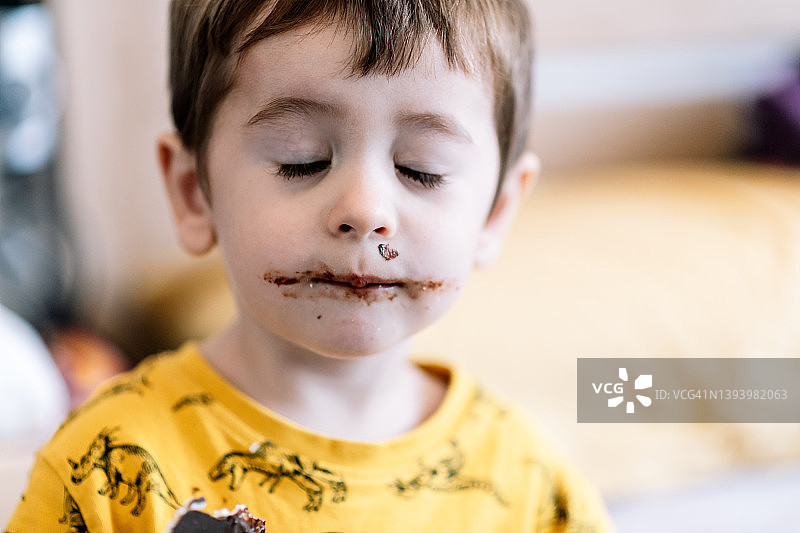 脸上沾巧克力的男孩特写图片素材
