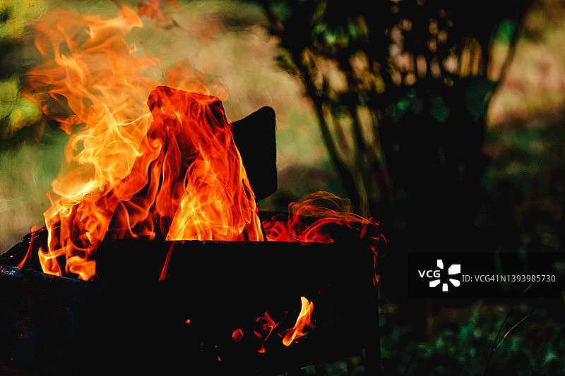 模糊花园背景下的篝火火焰图片素材