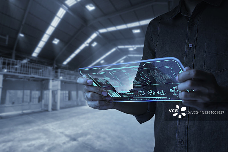 工程师在现代工业中手持机器人手臂控制面板图片素材