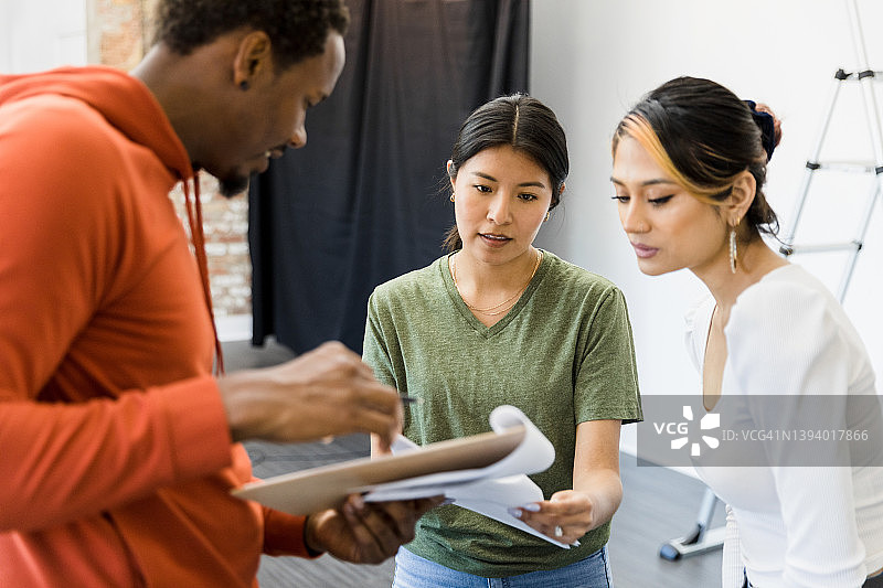 男选角导演与女演员一起审阅剧本图片素材