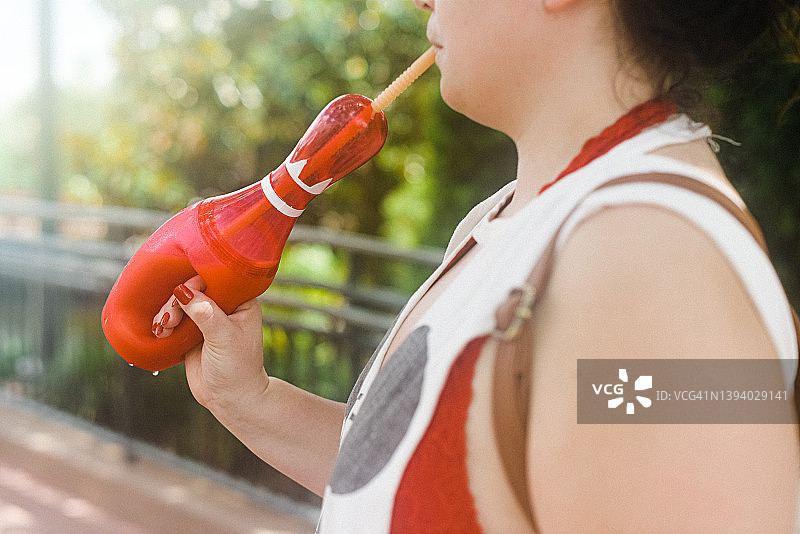 女孩用塑料杯喝冰沙图片素材