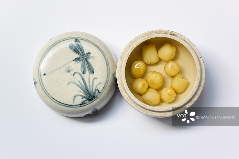 小陶瓷罐中的莲子甜汤配纹理盖图片素材