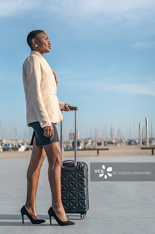 拉着行李箱的非裔美国女商人，商务旅行概念图片素材