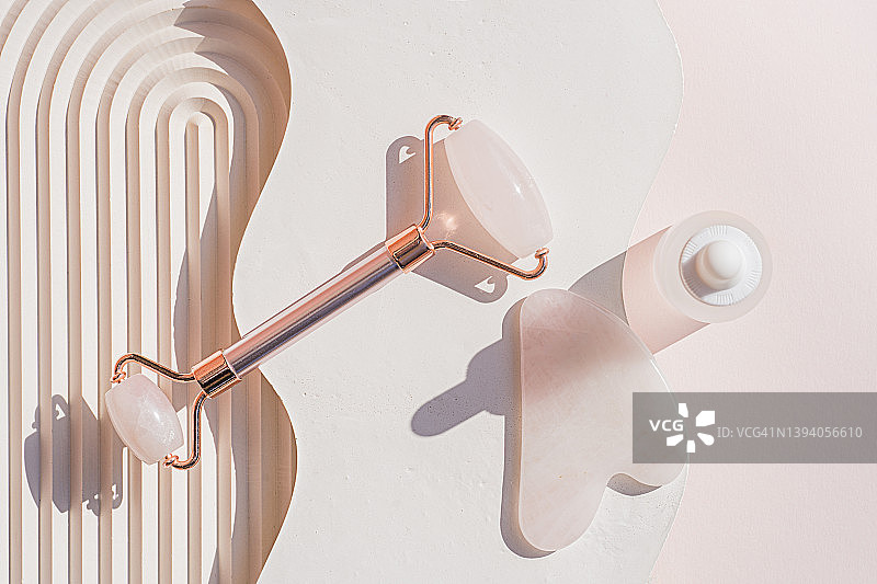 使用粉晶面部滚轮和刮痧板进行日常面部护理和按摩图片素材