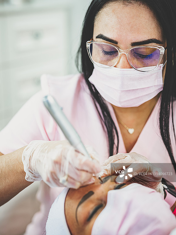 女美容师为顾客进行眉毛护理图片素材