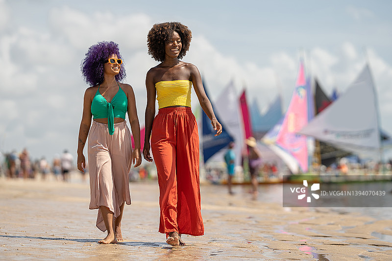 在热带海滩上行走的黑人女性图片素材
