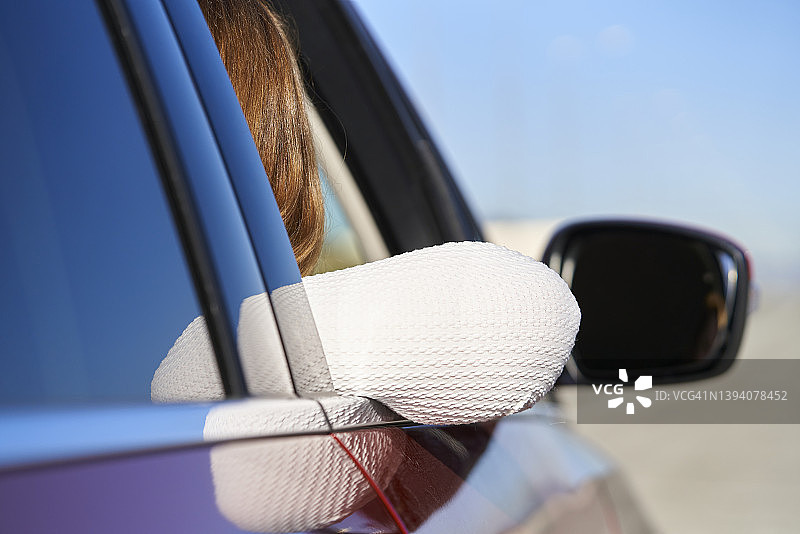 坐在车里，手肘伸出窗外的女人背影图片素材