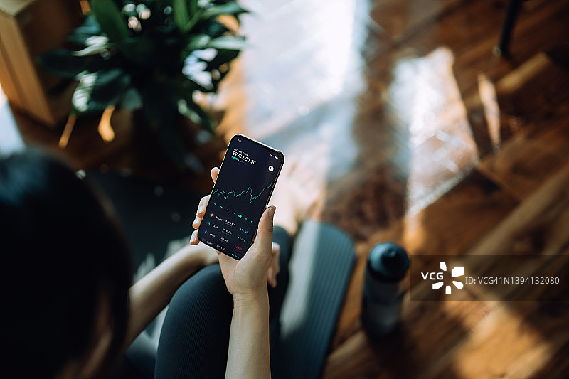 年轻亚洲运动女性用手机App投资NFT比特币数字资产图片素材