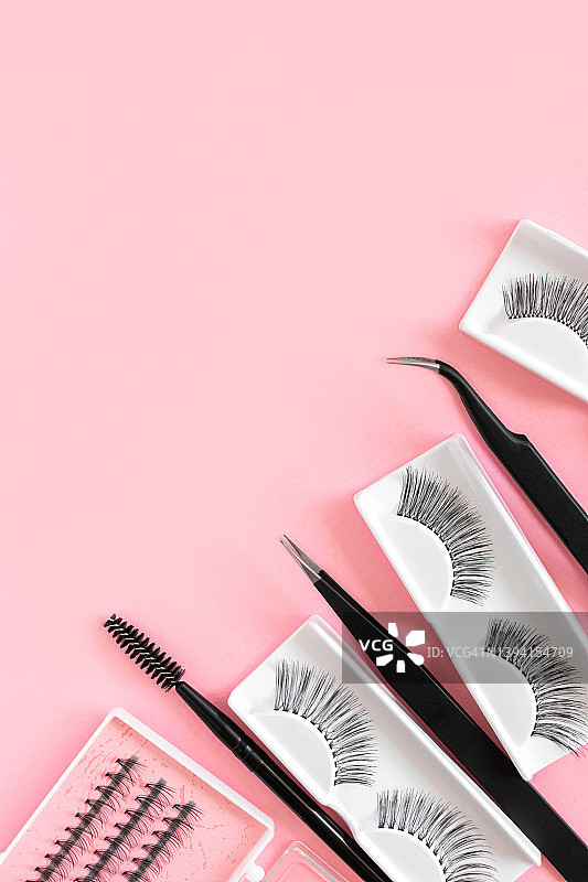 粉色背景上各种睫毛延长工具：睫毛、镊子等化妆配件，竖版banner，留有文本的复制空间图片素材