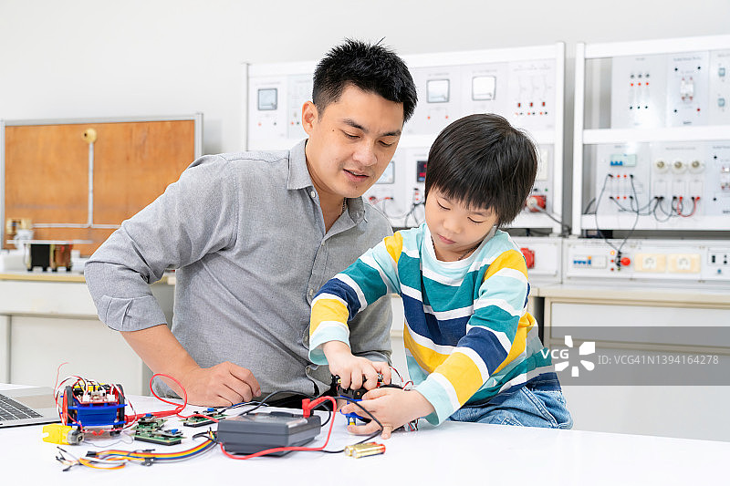 学生和老师学习建造小型机器人，并使用笔记本电脑为机器人工程课程编写软件。在小学科学课堂上，有才华横溢的孩子与科技一起工作图片素材