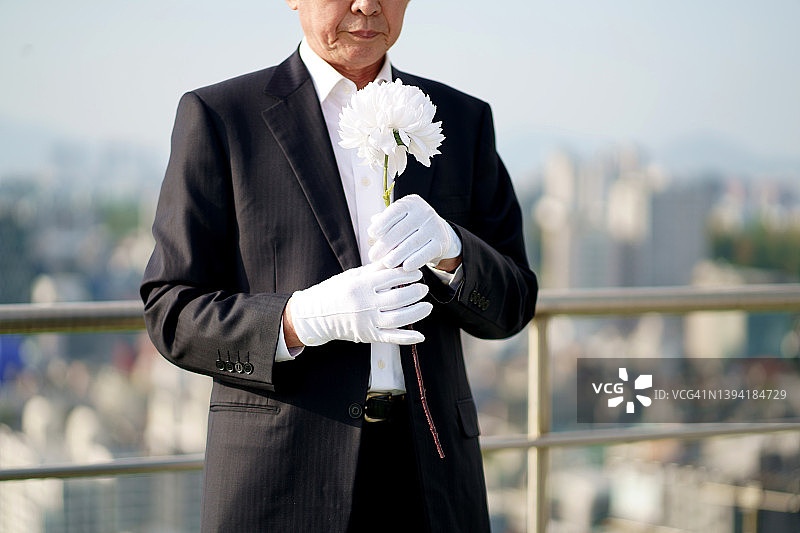 年长的男人拿着悼念鲜花图片素材