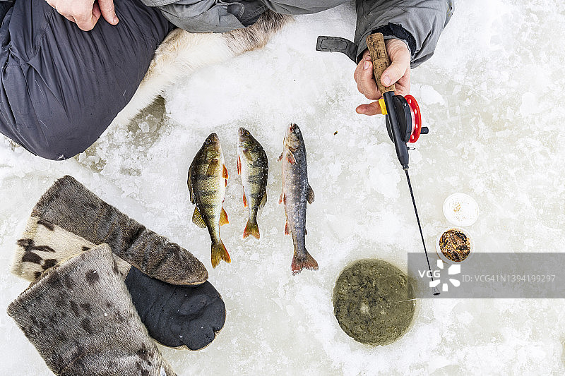 徒步者在瑞典拉普兰的冰冻湖面上冰钓图片素材