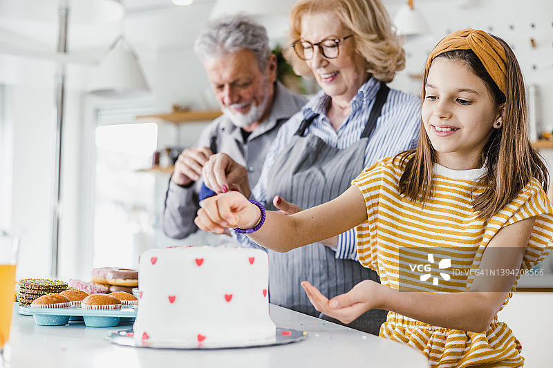 厨房里的小女孩和祖父母的肖像图片素材