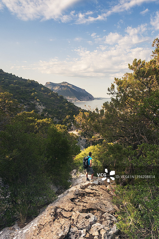 年轻男子徒步旅行，驻足欣赏眼前全景图片素材