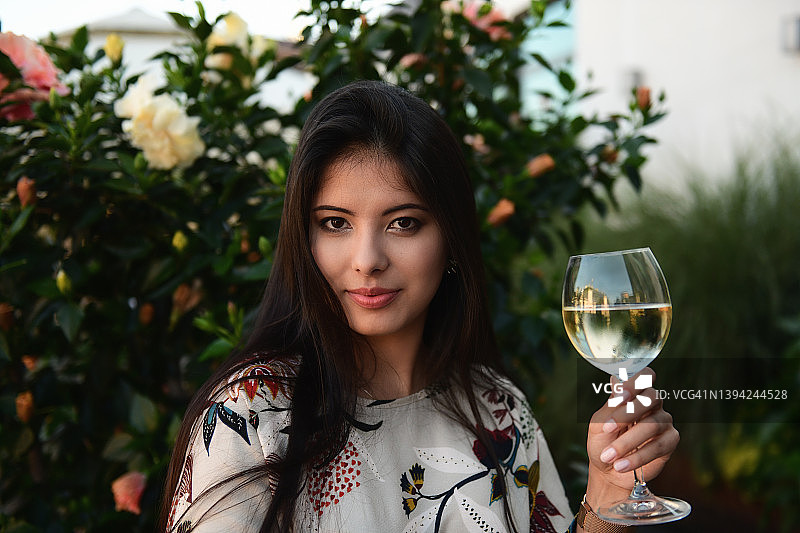 拿着一杯白葡萄酒的美丽年轻女人的肖像图片素材
