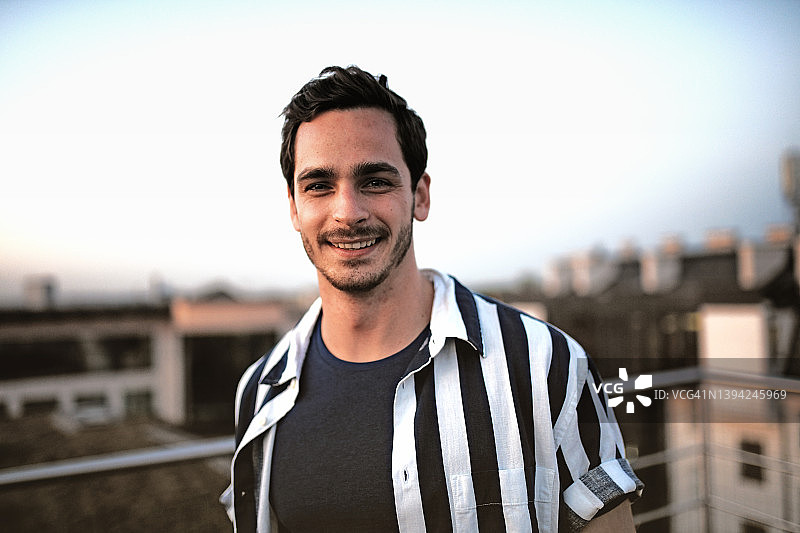 年轻男人屋顶露台看日落图片素材