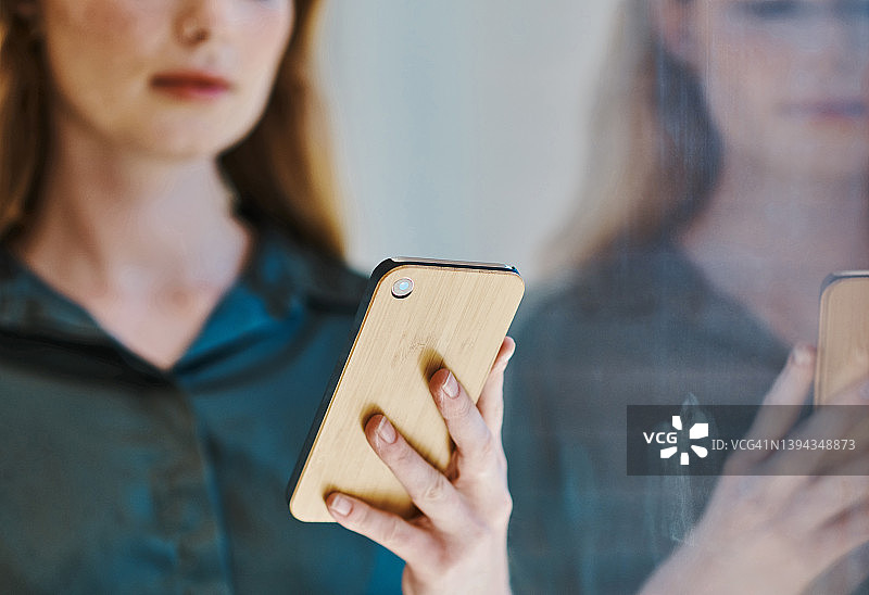 白人女性在办公室独自用手机浏览的手部特写图片素材