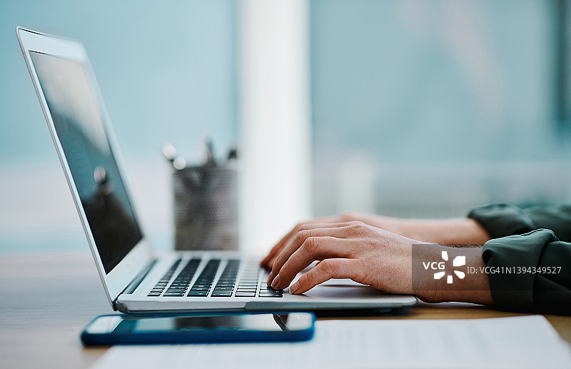 一位白人女商人独自在办公室里使用笔记本电脑图片素材