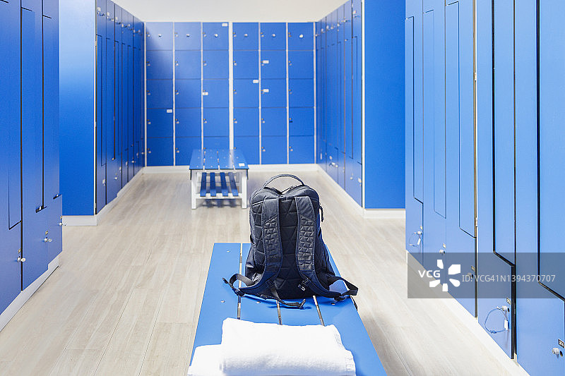健身房空更衣室长凳上的背包图片素材