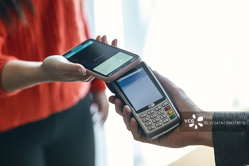 女人用手机进行非接触式支付图片素材