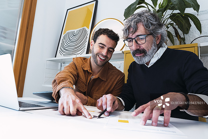 微笑的年轻自由职业者向同事讲解文件图片素材