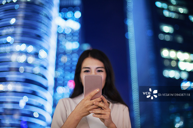 在中国广州市中心使用智能手机的年轻中国女人图片素材