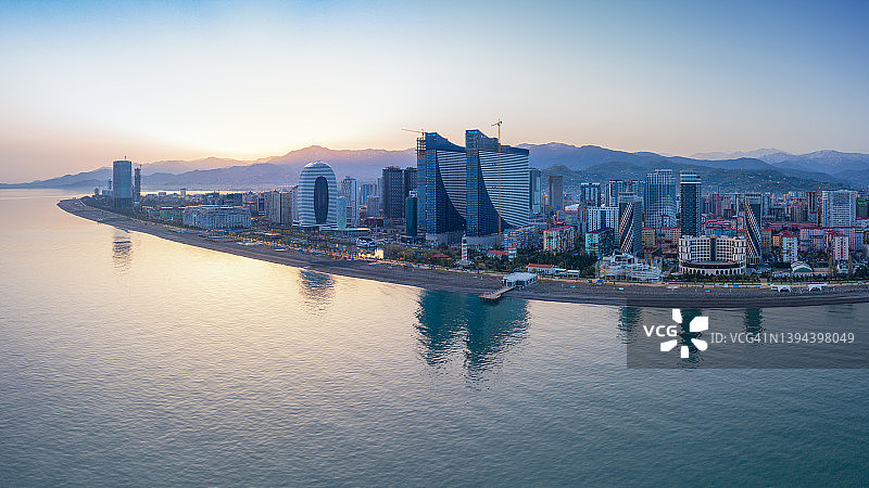海滨现代城市上空的宁静日出图片素材
