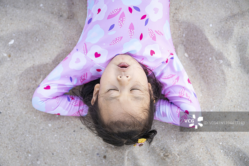 躺在沙滩上的小女孩图片素材