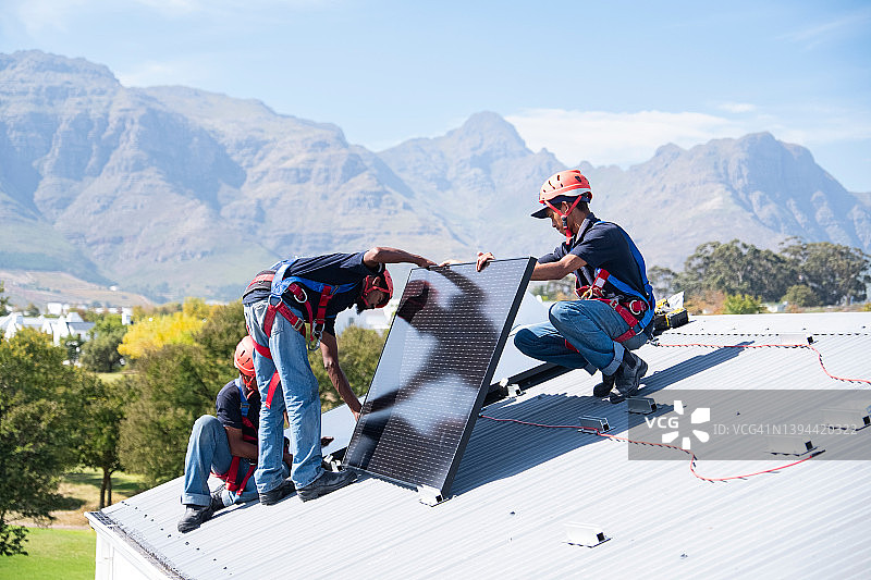 熟练工人连接并安装太阳能电池板图片素材