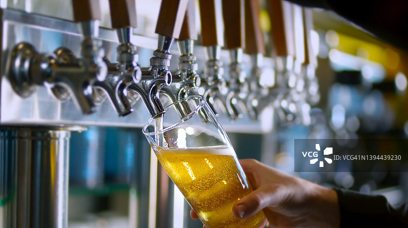 从水龙头倒入高脚啤酒杯图片素材