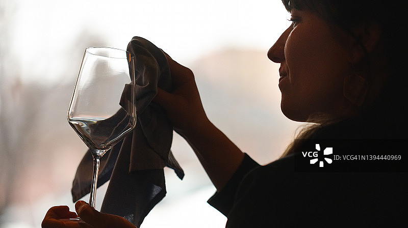 女人清洁和擦亮酒杯图片素材