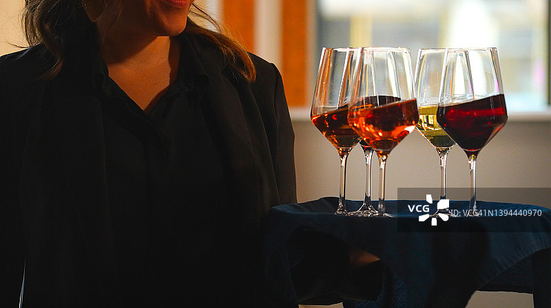 一位端着饮料托盘的迷人女性图片素材